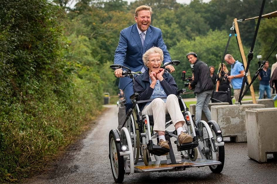 Roi des Pays-Bas Willem-Alexander brille sur vélo fauteuil roulant Van Raam au jubilé Zonnebloem